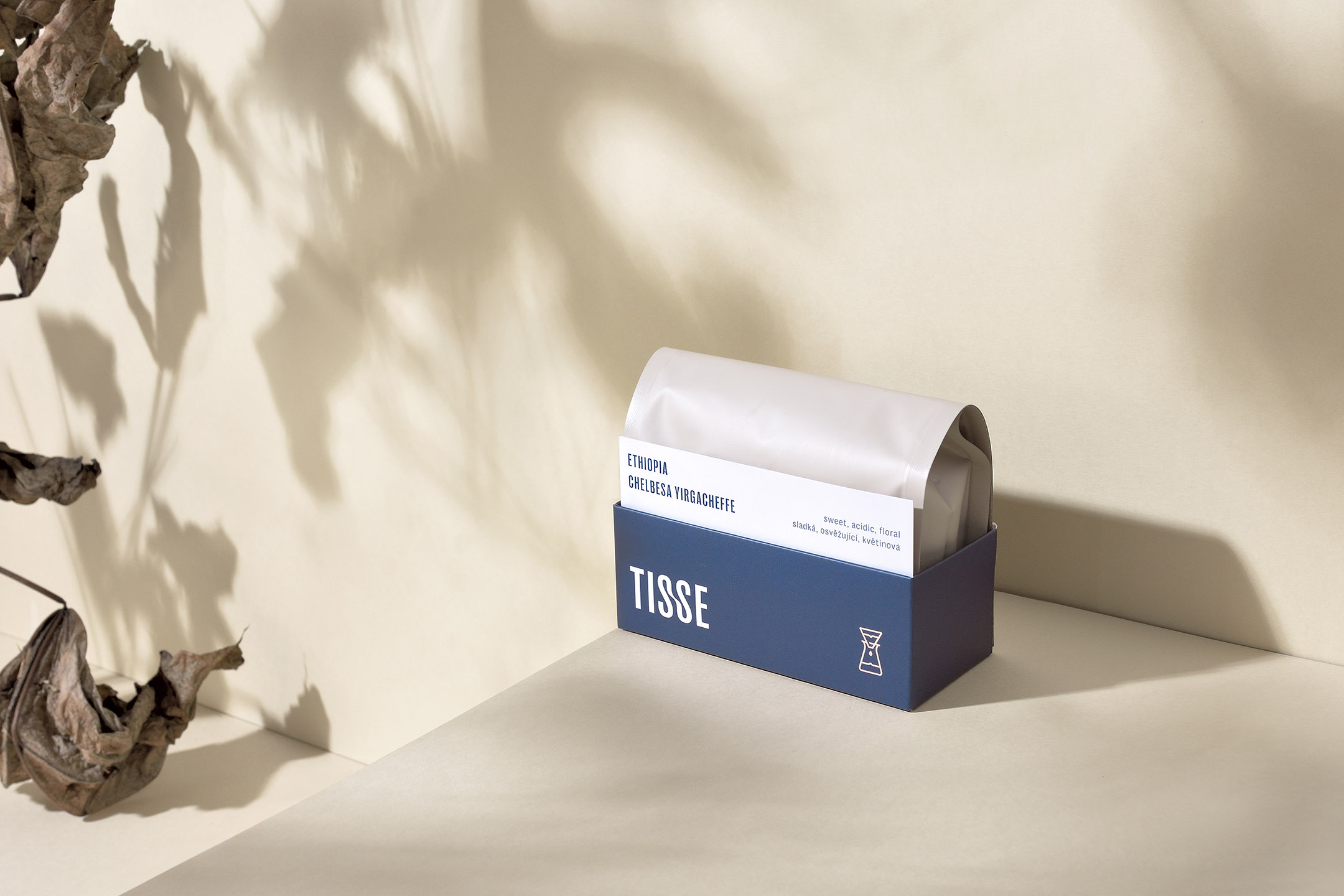 Tisse coffee packaging solo studio photo with artificial shadows and dry leaves