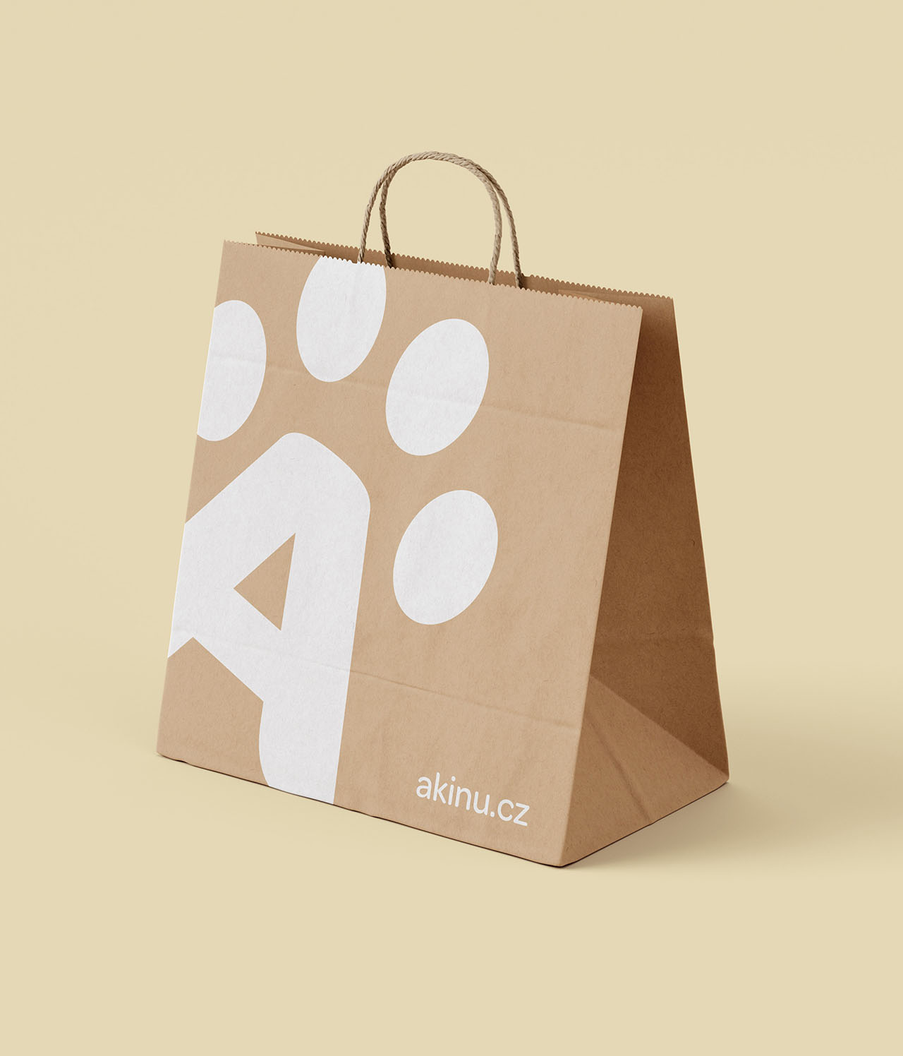 Akinu paper bag with large white logo on light beige background mockup